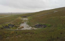 Stormwater runoff carrying loose sediment, which settled within downgradient ends of the concrete drainage channels.